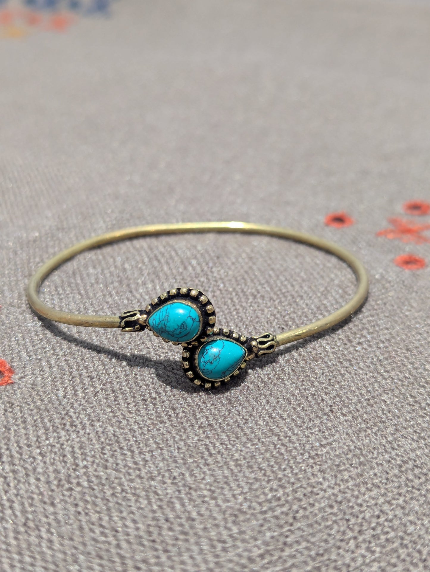 This Oxidized Matt Gold Bracelet features two pear-drop turqoise stones. Snag this piece to add to your budding ethnic jewellery collection or to on-ward gift. 